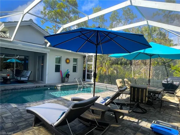 a view of a patio with table and chairs under an umbrella