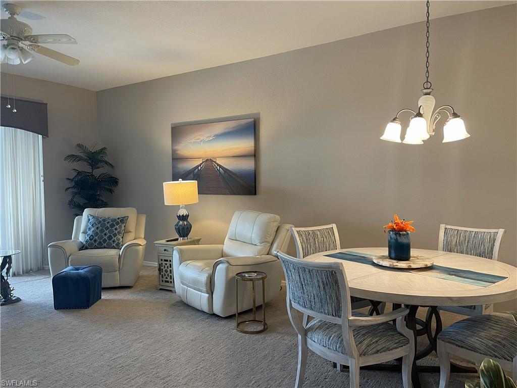 3532 Periwinkle Way, Unit 11 Naples, FL 34114 - Photo 10 of 37 a living room with furniture and a chandelier