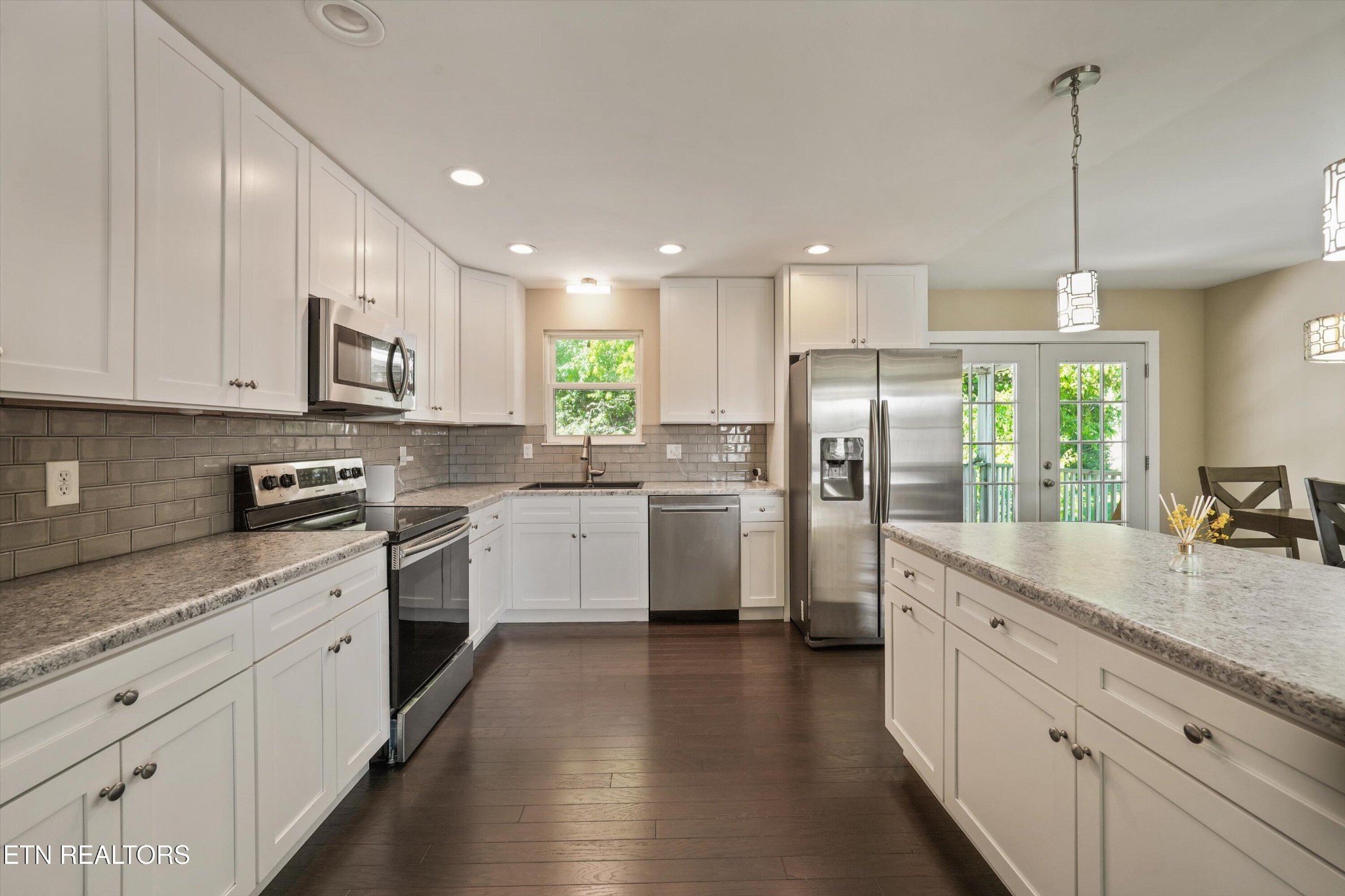 7613 Fall Wind Court Powell, TN 37849 - Photo 7 of 38 a kitchen with stainless steel appliances granite countertop a refrigerator a sink dishwasher a stove and white cabinets with wooden floor