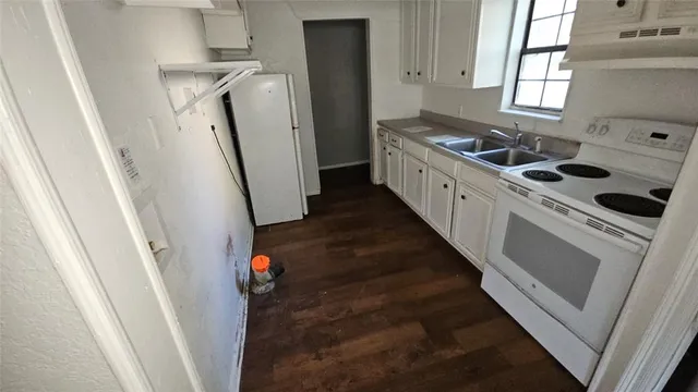 a kitchen with refrigerator a stove and a window