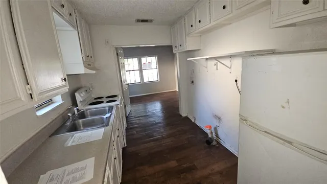 a kitchen with granite countertop a refrigerator and a sink