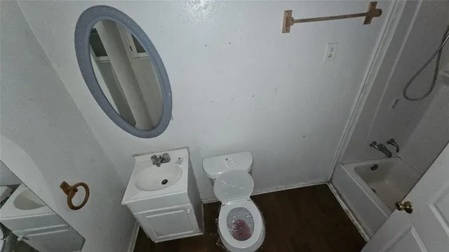 an empty room with wooden floor closet and windows