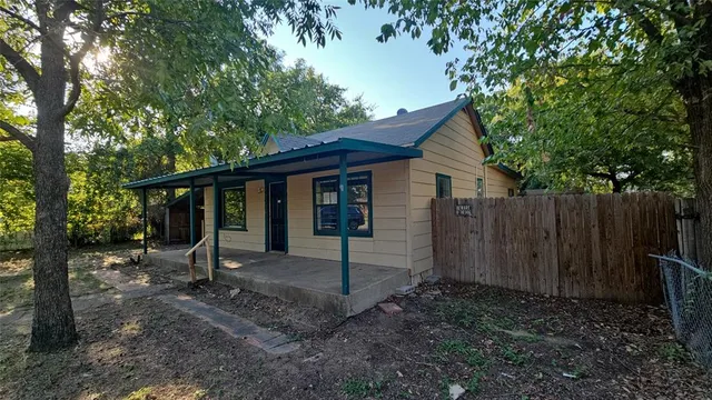a backyard of a house with barbeque oven