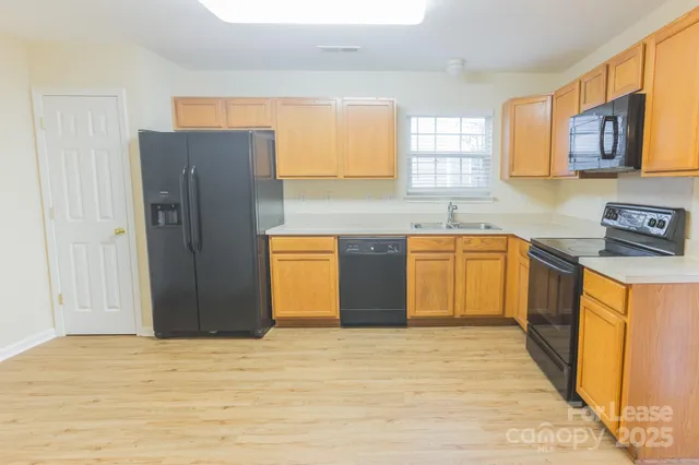 a kitchen with stainless steel appliances granite countertop a refrigerator sink and cabinets