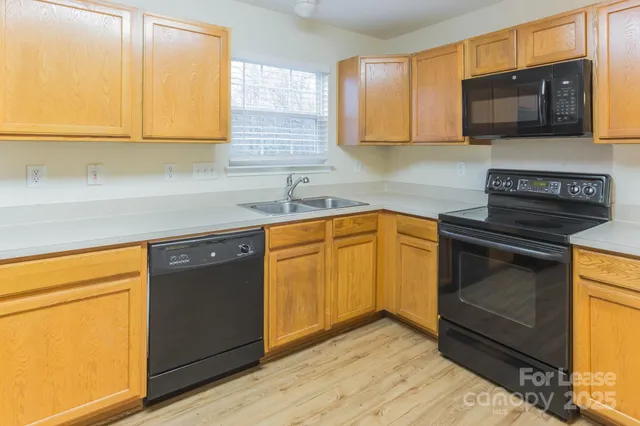 a kitchen with granite countertop cabinets stainless steel appliances and a counter space