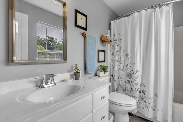 a living room with furniture and a dining table with bookshelf