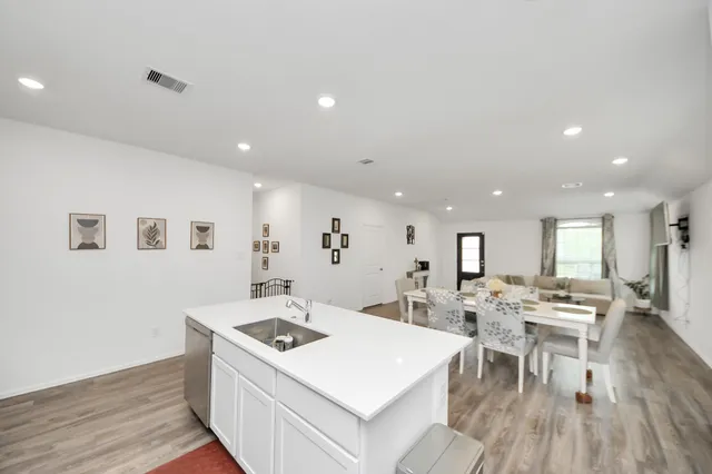 a large white kitchen with sink stove and refrigerator