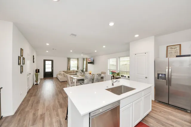 a kitchen with a sink a counter top stainless steel appliances and cabinets
