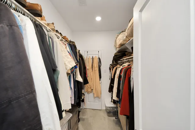 a view of walk in closet with clothes