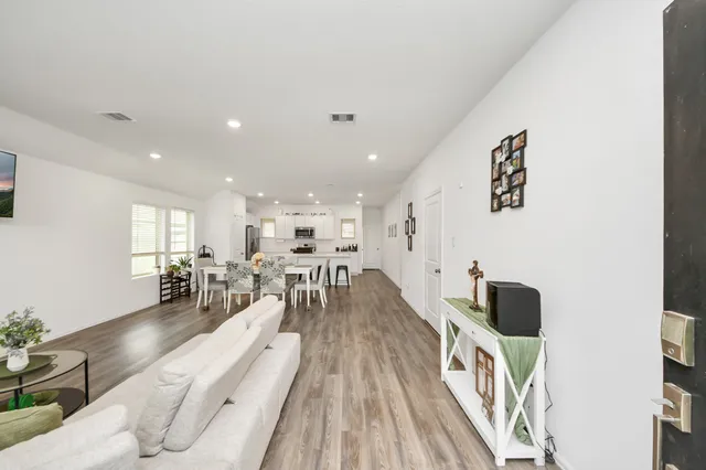 a living room with furniture and a wooden floor
