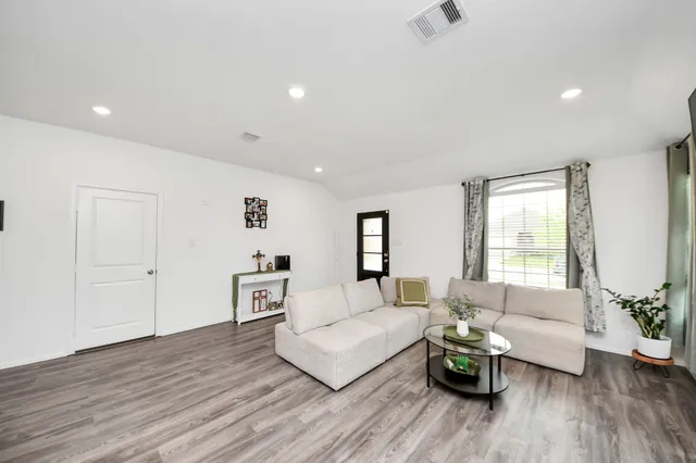 a living room with furniture and wooden floor
