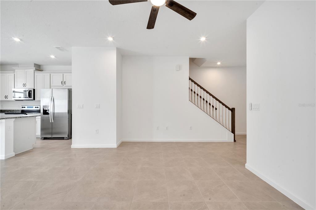 9068 Ocean Tide Way Kissimmee, FL 34747 - Photo 16 of 42 a view of a kitchen with a sink and dishwasher a refrigerator with wooden floor