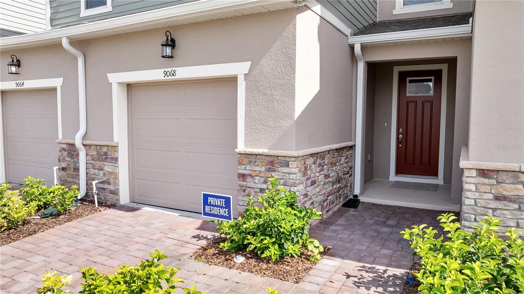 9068 Ocean Tide Way Kissimmee, FL 34747 - Photo 2 of 42 a front view of a house with plants