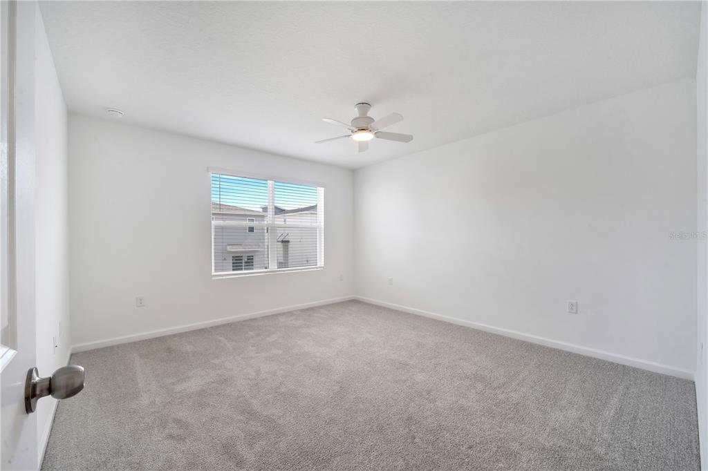 9068 Ocean Tide Way Kissimmee, FL 34747 - Photo 21 of 42 an empty room with a window and a ceiling fan