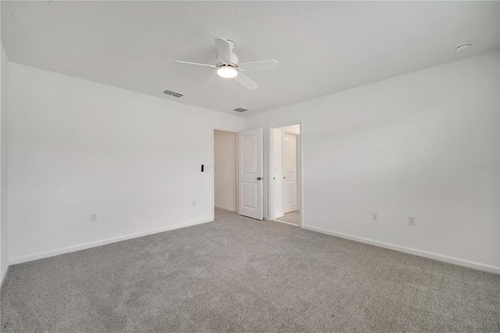 9068 Ocean Tide Way Kissimmee, FL 34747 - Photo 22 of 42 a view of an empty room with a ceiling fan