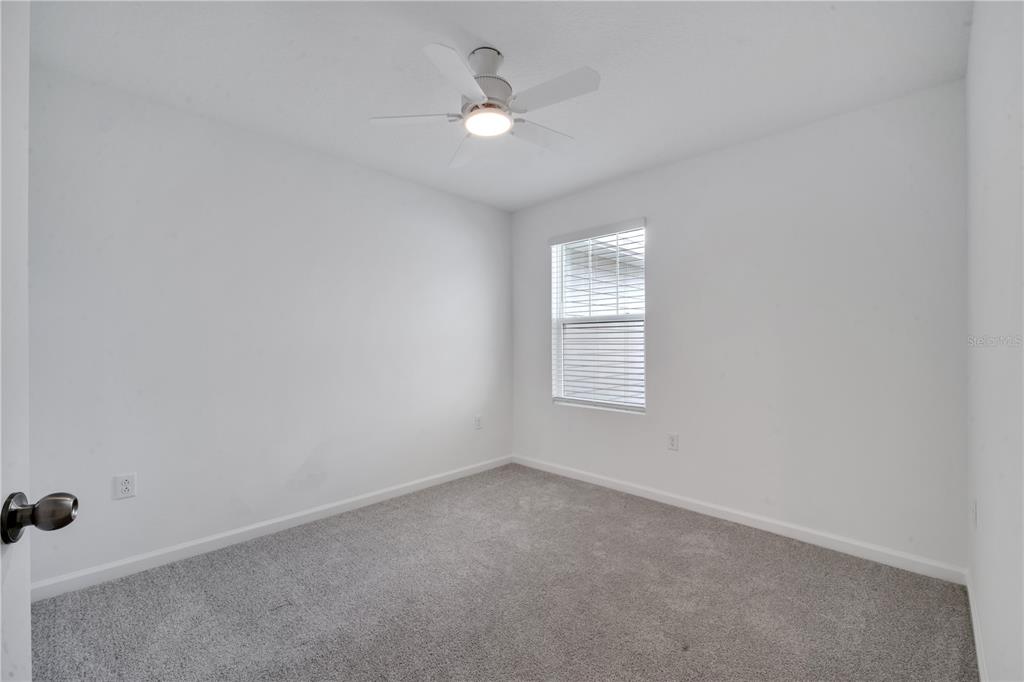 9068 Ocean Tide Way Kissimmee, FL 34747 - Photo 31 of 42 an empty room with a window and a ceiling fan