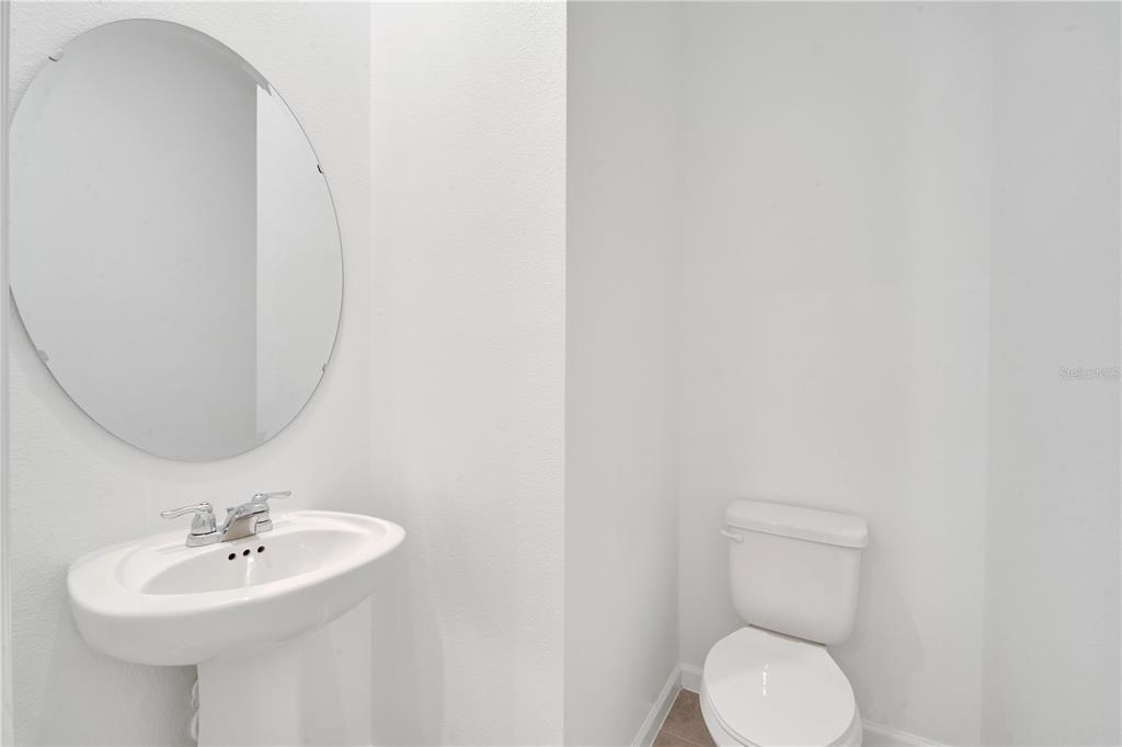 9068 Ocean Tide Way Kissimmee, FL 34747 - Photo 6 of 42 a bathroom with a sink a toilet and mirror