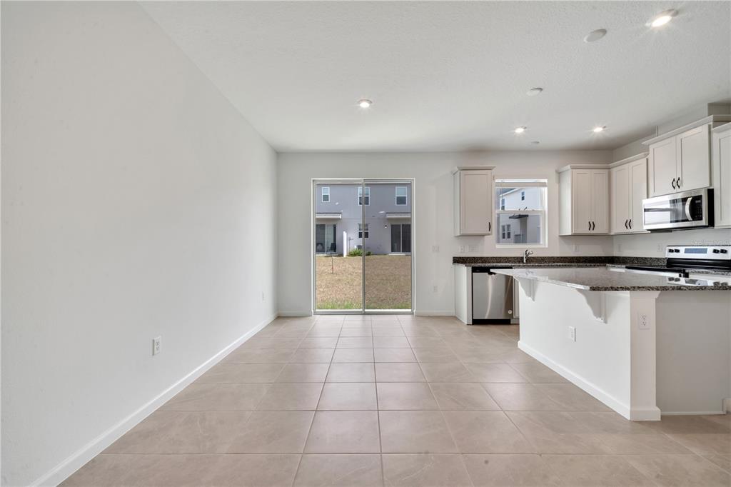 9068 Ocean Tide Way Kissimmee, FL 34747 - Photo 9 of 42 a large kitchen with a large counter top a sink stainless steel appliances and cabinets