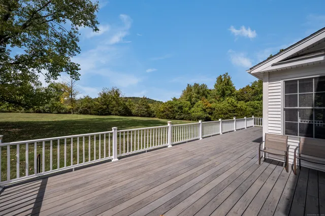 a view of a roof deck with chair and wooden floor