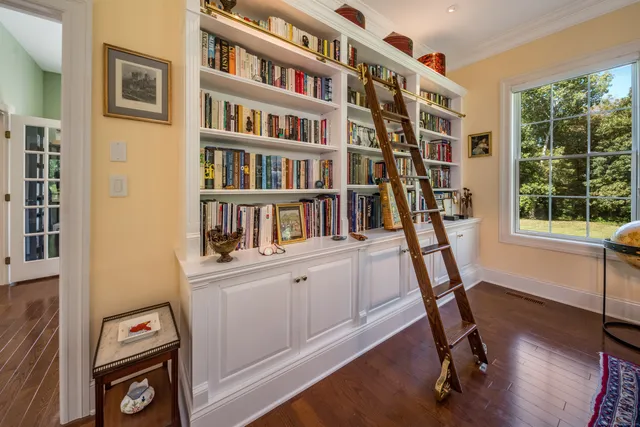 a view of a workspace with furniture and a book shelf