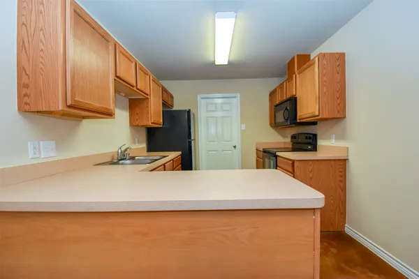 a room with a sink a bed and a cabinets