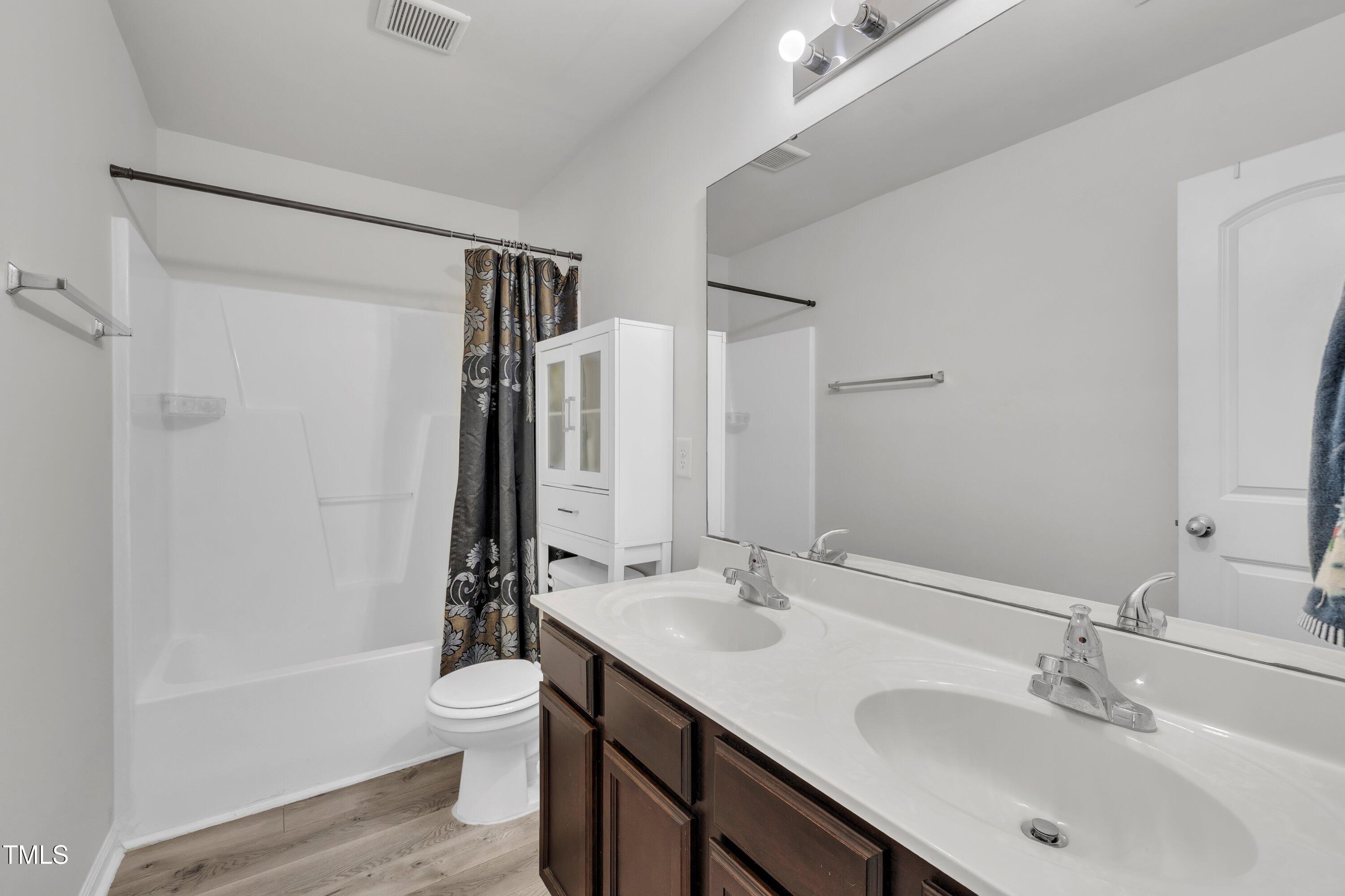 2816 Erinridge Road Raleigh, NC 27610 - Photo 12 of 20 a bathroom with a sink double vanity granite toilet and a tub