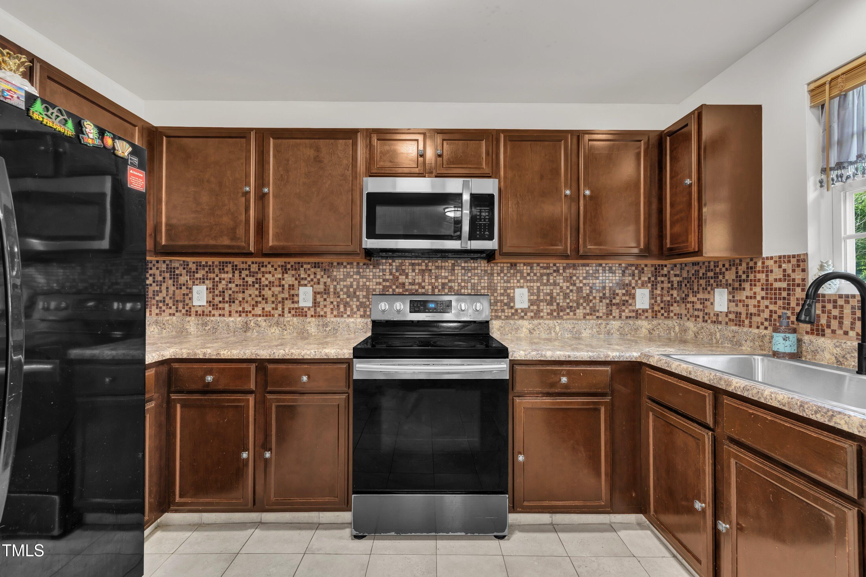 2816 Erinridge Road Raleigh, NC 27610 - Photo 5 of 20 a kitchen with stainless steel appliances granite countertop a stove microwave and sink