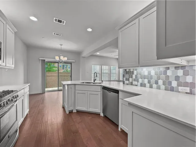 a kitchen with a sink stove and cabinets