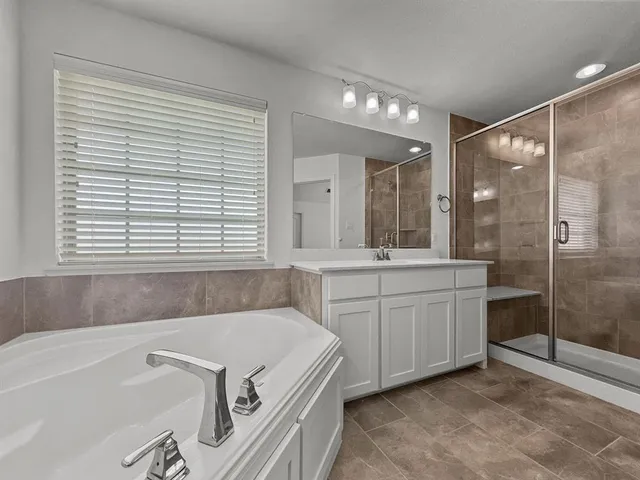 a bathroom with a granite countertop sink mirror and a bathtub