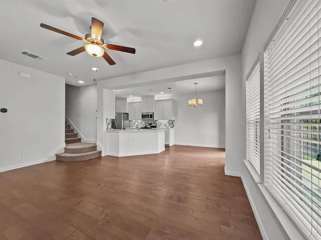 a view of a livingroom with a ceiling fan and wooden floor