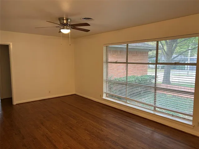 a view of a livingroom with wooden floor and a window
