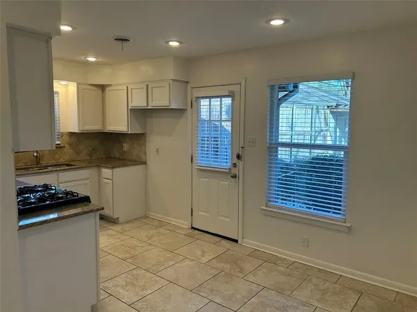 a kitchen with granite countertop a stove a sink and a microwave