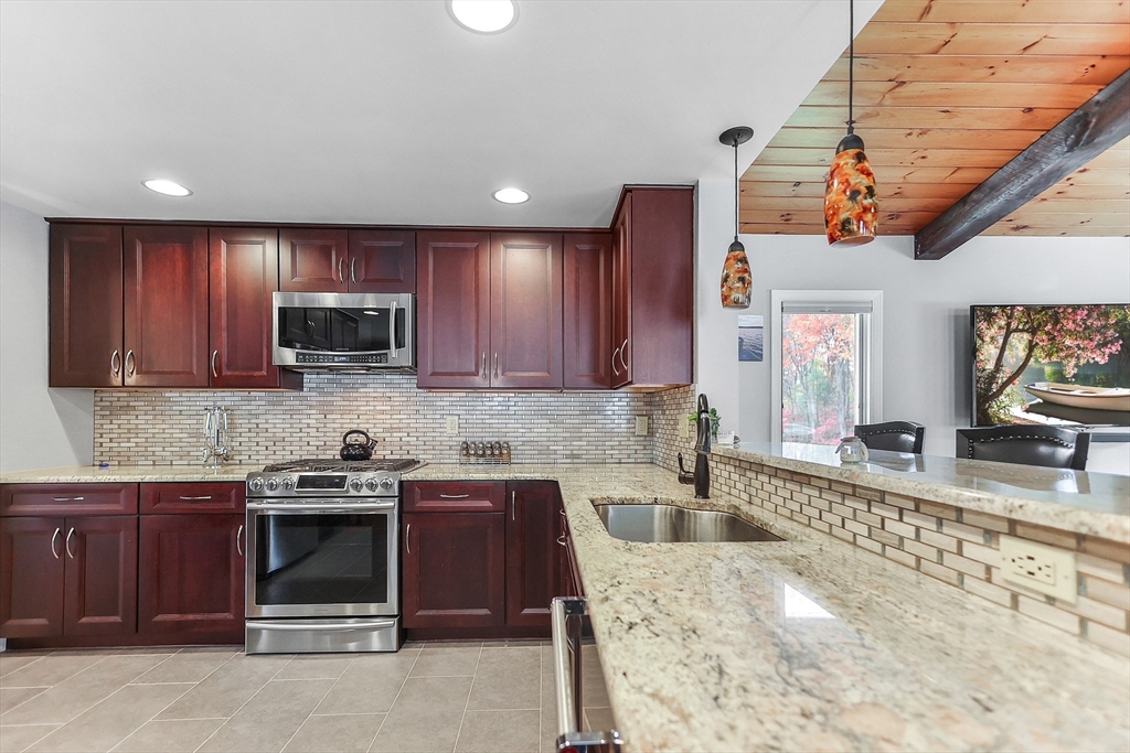 86 Butternut Lane Methuen, MA 01844 - Photo 11 of 32 a kitchen with a sink stove top oven and cabinets
