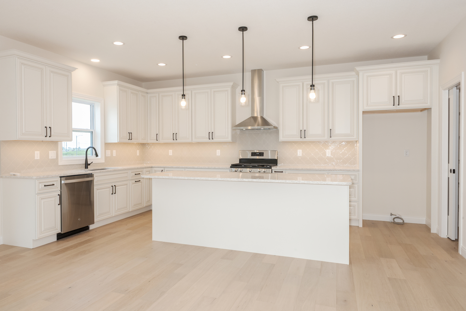1313 Woodbine Road Bloomington, IL 61704 - Photo 41 of 67 a kitchen with a stove a sink a refrigerator a center island and cabinets