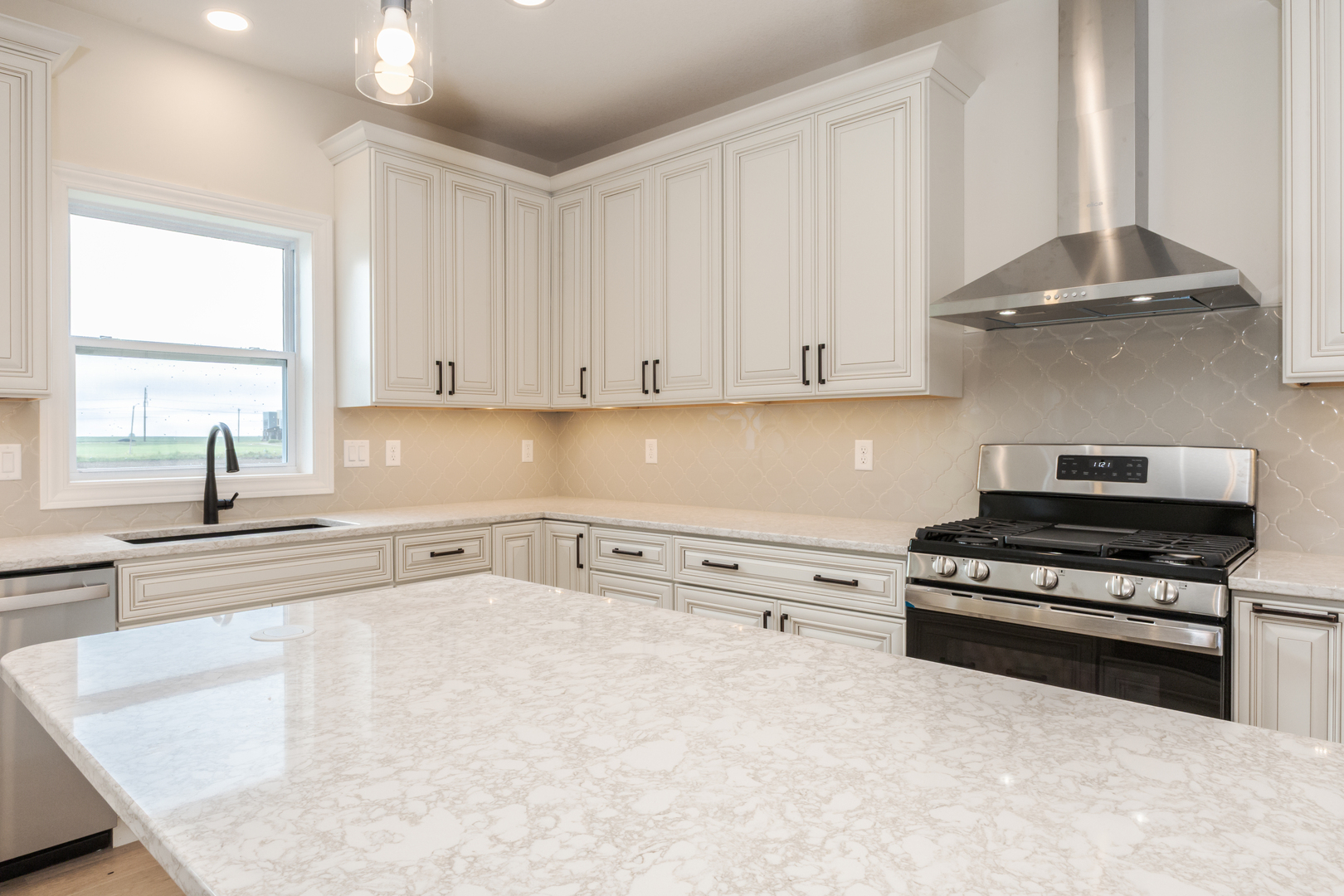 1313 Woodbine Road Bloomington, IL 61704 - Photo 44 of 67 a kitchen with granite countertop a stove a sink and white cabinets