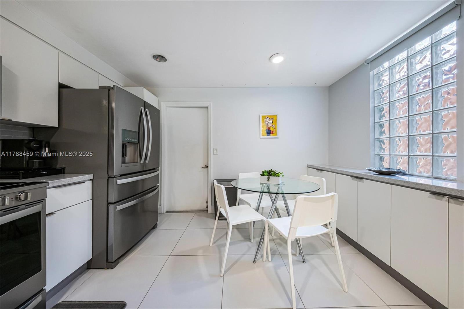 1524 Coronado Road, Unit 535 Fort Lauderdale, FL 33327 - Photo 15 of 54 a kitchen with stainless steel appliances a refrigerator a stove a sink and dishwasher with a dining table