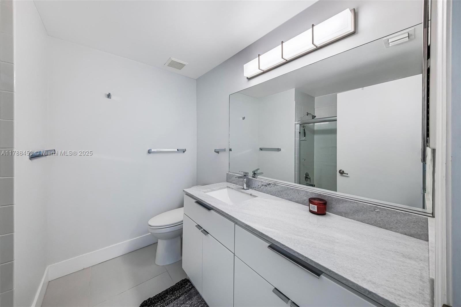 1524 Coronado Road, Unit 535 Fort Lauderdale, FL 33327 - Photo 27 of 54 a bathroom with a granite countertop sink a toilet and a mirror