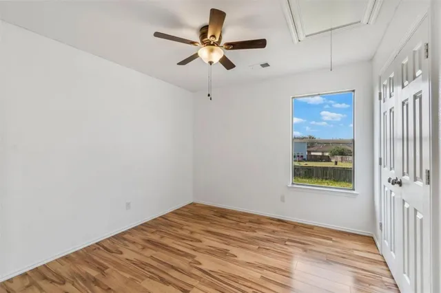a view of an empty room with wooden floor