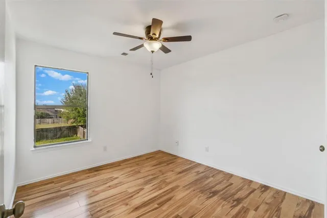 a view of room with hardwood floor and ceiling fan