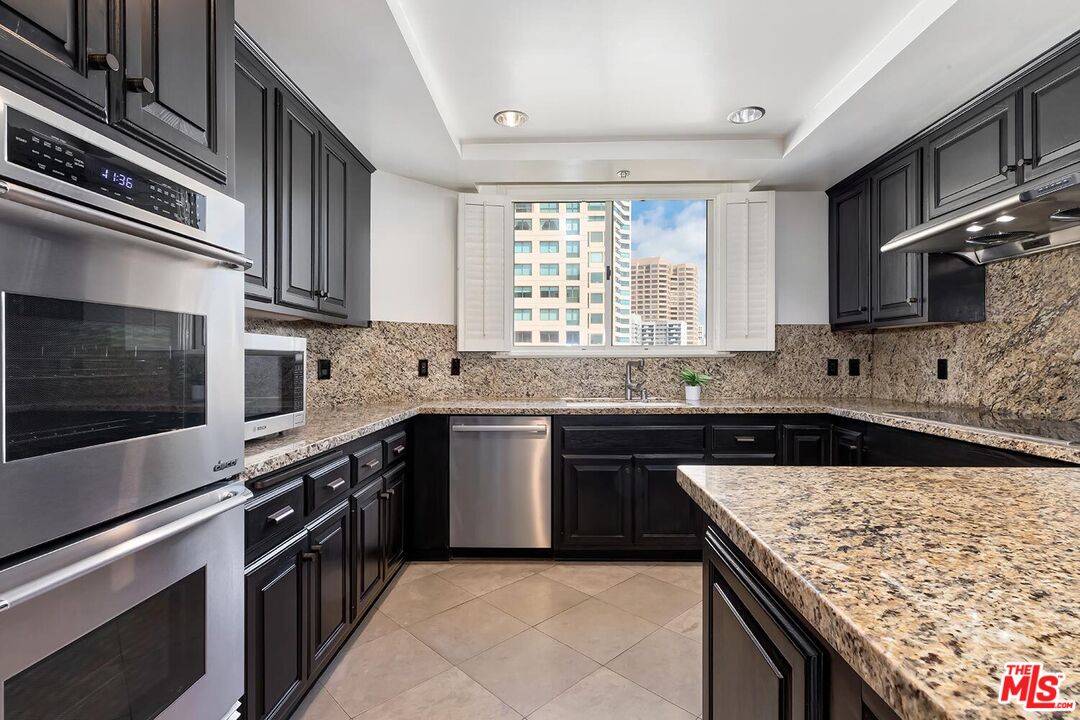 10550 Wilshire Boulevard, Unit 804 Los Angeles, CA 90024 - Photo 12 of 22 a kitchen with stainless steel appliances granite countertop a stove microwave and sink