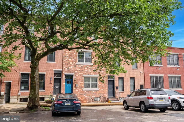 a car parked in front of a houses on the roadside