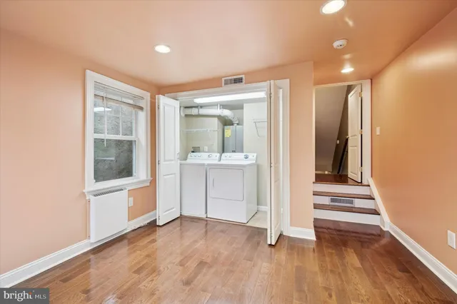 a view of a hallway with wooden floor and cabinet