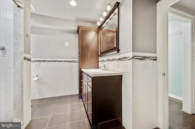 a bathroom with a double vanity sink mirror and shower