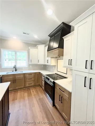 a kitchen with granite countertop a sink stainless steel appliances and white cabinets