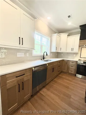 a kitchen with a stove and a wooden floor