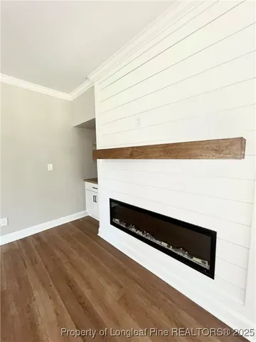 a view of an empty room with wooden floor and a cabinet