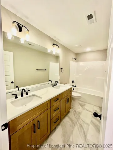 a bathroom with a sink a toilet a mirror and vanity