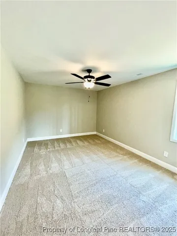 a living room with a floor to ceiling window and a ceiling fan