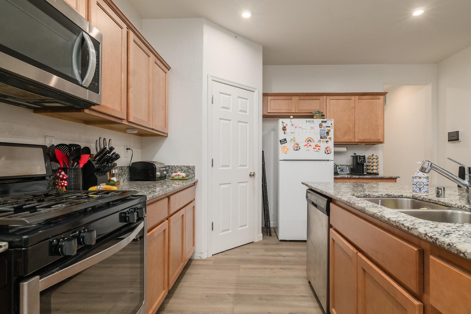 1945 East Gum Avenue Reedley, CA 93654 - Photo 12 of 31 a kitchen with stainless steel appliances granite countertop a refrigerator stove and sink