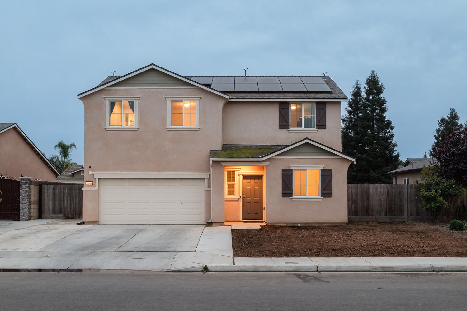 1945 East Gum Avenue Reedley, CA 93654 - Photo 2 of 31 a front view of a house with a yard and garage